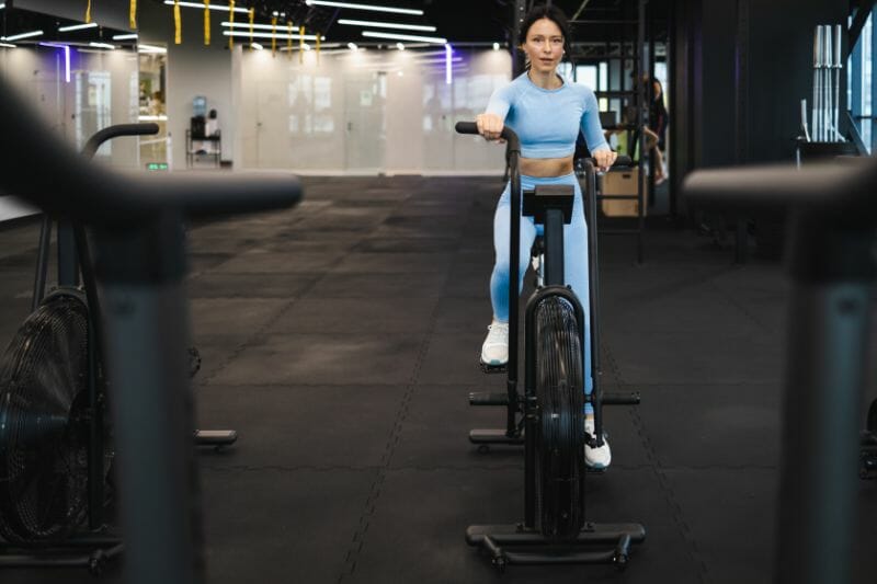 sportswoman pedaling indoor bike