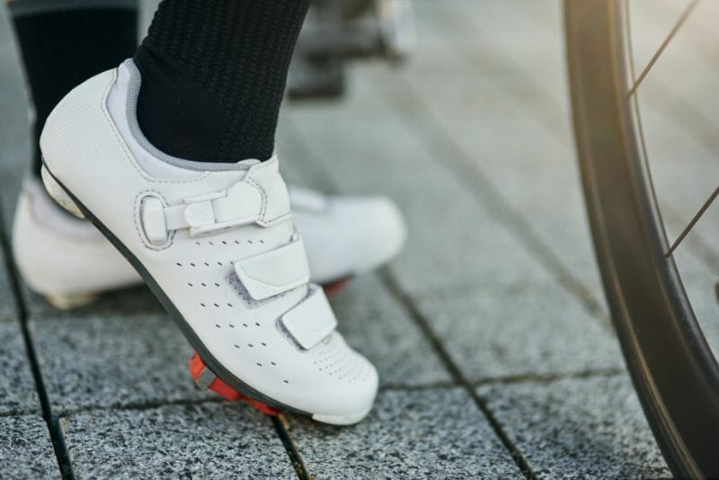 close up shot of female cyclist leg wearing cycling shoes with delta cleats