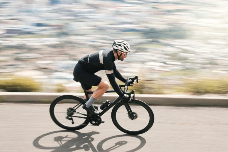 male cyclist riding against the headwind to improve cycling power