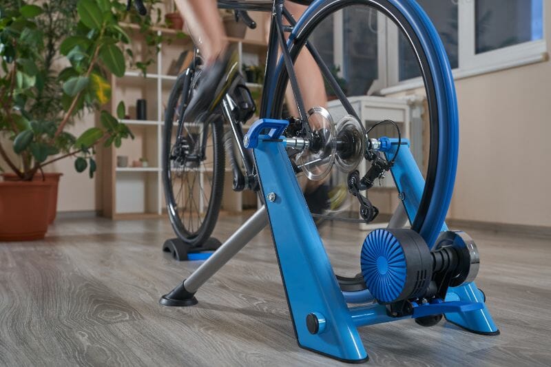 man-doing-training-on-a-cycle-trainer-at-home